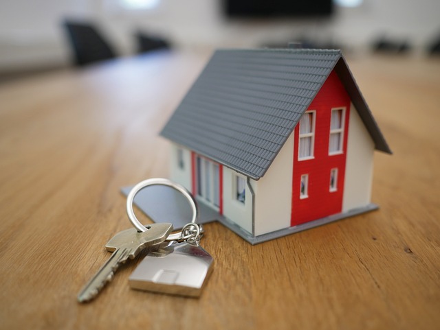 set of keys next to a small model house
